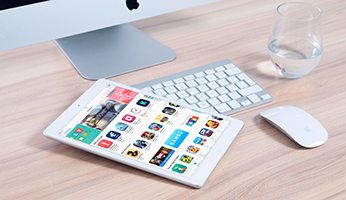 Tableta con aplicaciones en mesa de ordenador